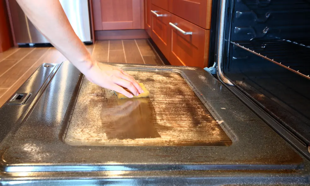 cleaner wiping kitchen oven